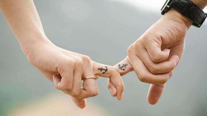 Locked fingers with anchor tattoos