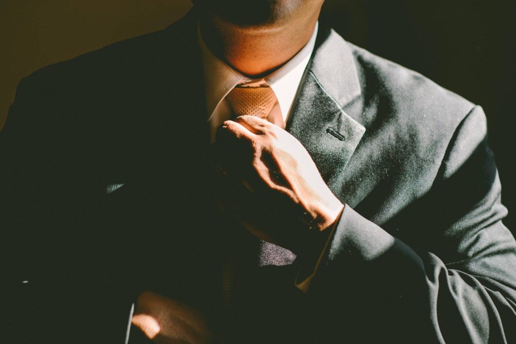 Man in suit tying tie