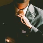 Man in suit tying tie