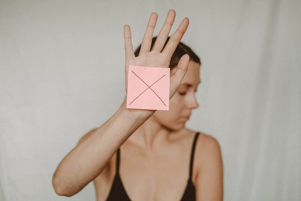 Woman holding up paper with X mark