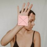 Woman holding up paper with X mark
